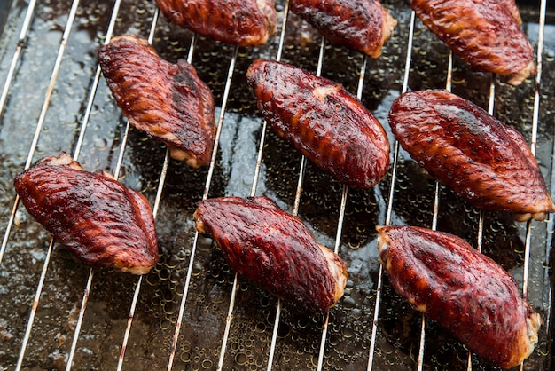 Tasty pieces of chicken meat on metal grill