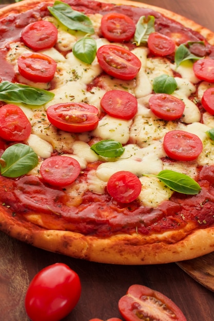 Tasty pizza with tomatoes slices; basil and cheese
