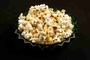 Free photo tasty popcorn bright yummy salted inside round plate on a dark