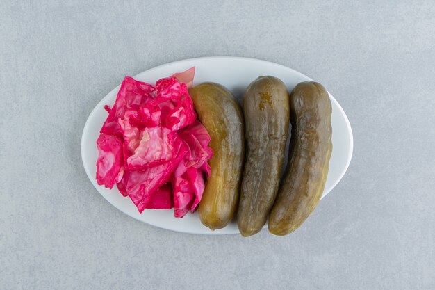 Tasty red sauerkraut and cucumber on a plate    