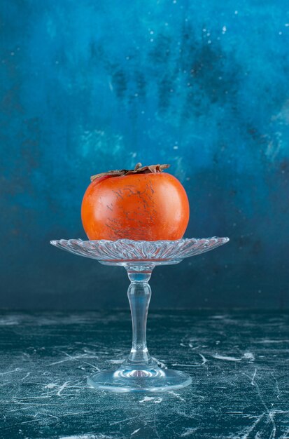 Tasty ripe persimmon on glass plate. 