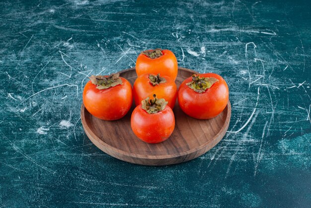 木の板に美味しい熟した柿。