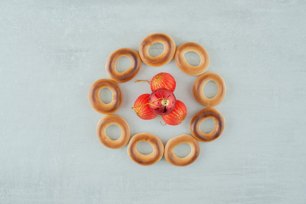 Вкусное круглое сладкое печенье с красными елочными шарами на белом фоне. Фото высокого качества