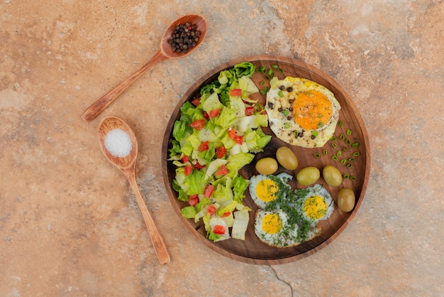 Free photo tasty salad with eggs on wooden board .