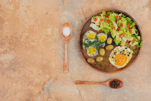 Gustosa insalata con uova su tavola di legno.