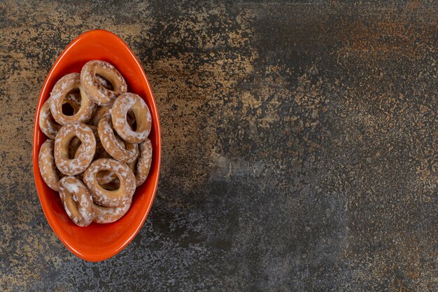 Tasty salted crackers in orange bowl.