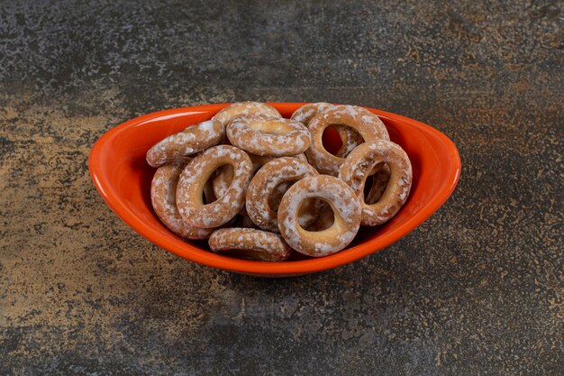 Tasty salted crackers in orange bowl.