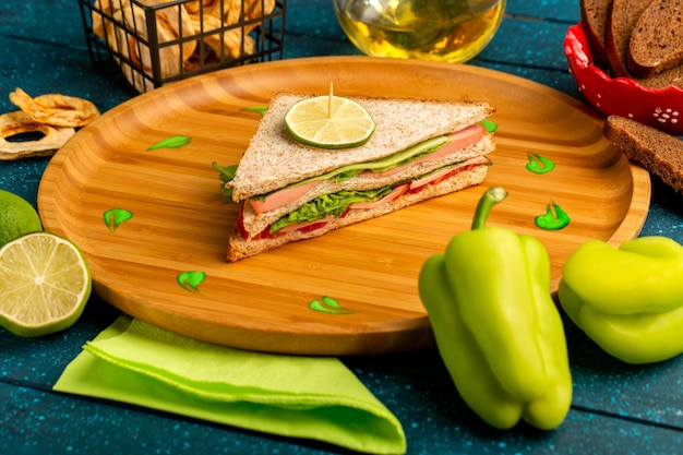 вкусный бутерброд с маслом зеленого болгарского перца и лимоном на синем