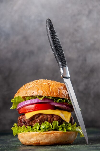 Tasty sandwich and knife on dark mix color surface with free space