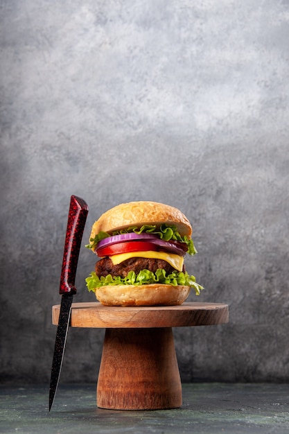 Вкусный бутерброд и красная вилка на деревянной доске на поверхности темного цвета со свободным пространством