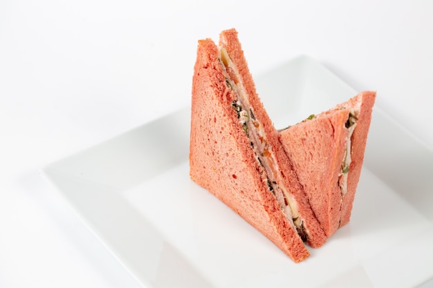 白いプレートにピンクのパンとおいしいサンドイッチ