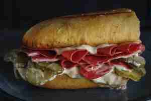 Foto gratuita panino gustoso con salame cetrioli sottaceto e maionese servito sul piatto