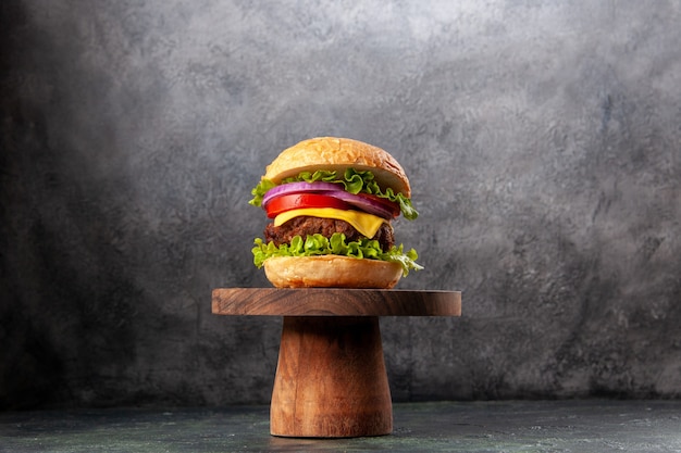 Tasty sandwich on wooden cutting board on dark mix color surface