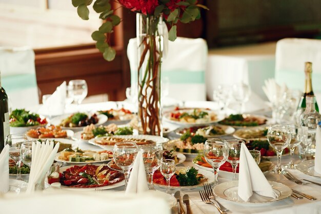 Вкусные закуски с овощами и мясом стоят на круглом столе