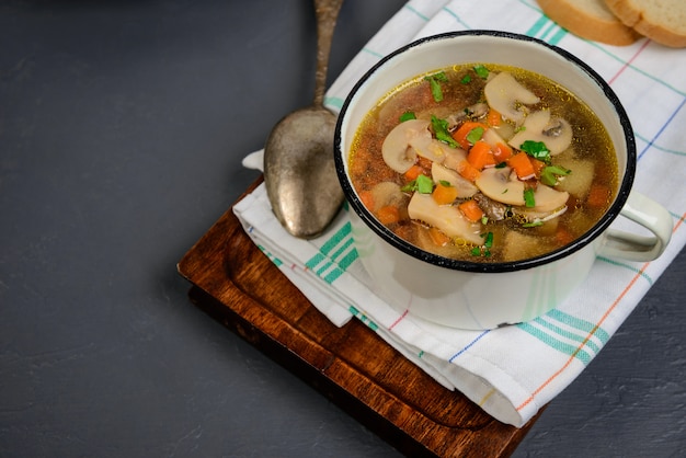 Бесплатное фото Вкусный суп в сковороде над серой поверхностью. закройте копировать пространство