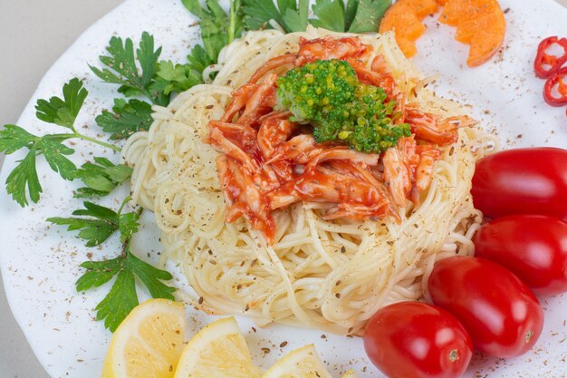 Tasty spaghetti with chicken and vegetables on white plate