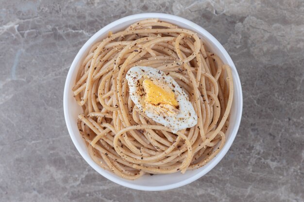 Вкусные спагетти с яйцом в белой миске.