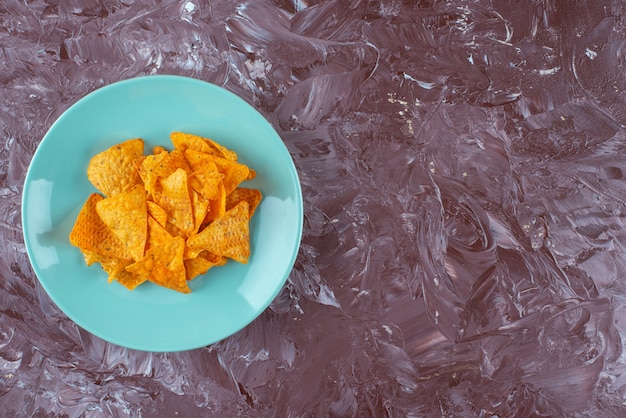 Free photo tasty spicy chips on a plate , on the marble table.