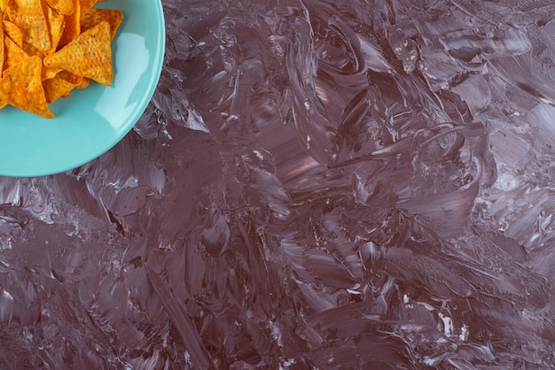 Tasty spicy chips on a plate , on the marble table. 