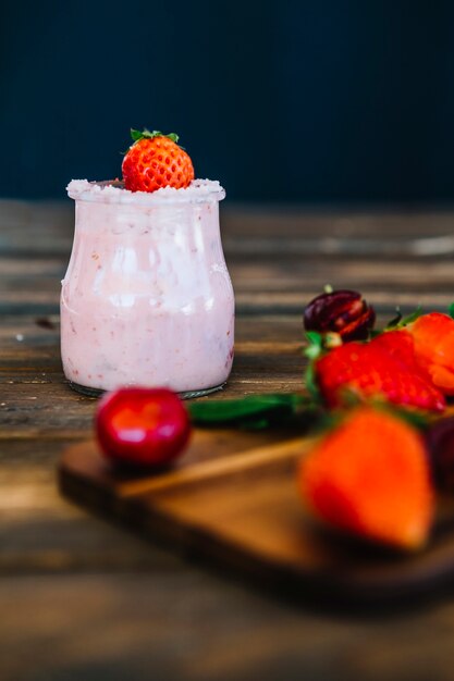 Tasty strawberry smoothie on wooden table
