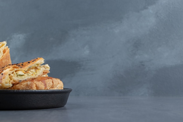 Tasty stuffed pastries on black plate. 