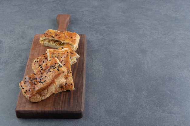 Tasty stuffed pastries on wooden board.