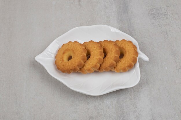 Tasty sweet biscuits on leaf shaped plate.