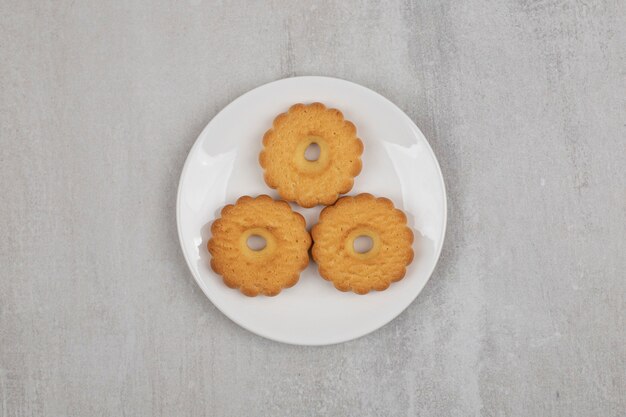 Tasty sweet biscuits on white plate.