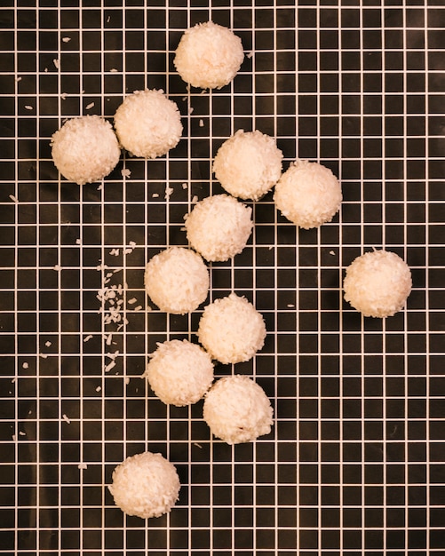 Foto gratuita gustose palline di cocco dolce su tessuto a scacchi