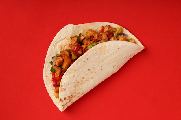 Tasty taco on red background, close up
