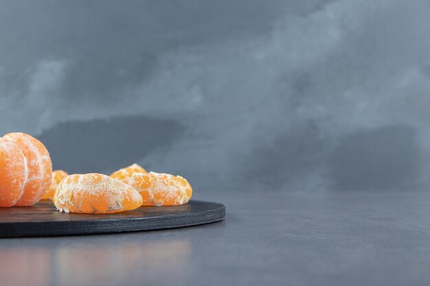 Tasty tangerine slices on cutting board. 