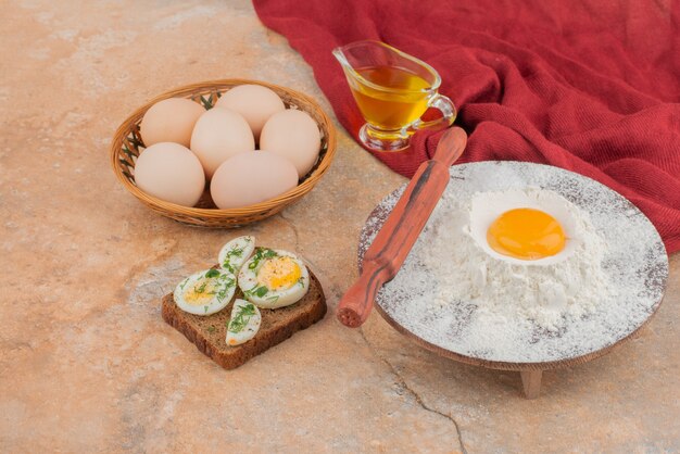 Tasty toast with several eggs and oil on marble table .