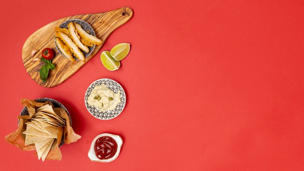 Tasty tortilla pieces with dips and fried chicken