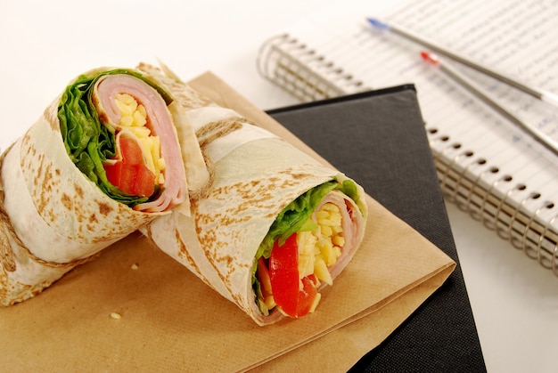 Tasty tortilla wrap on a paper bag