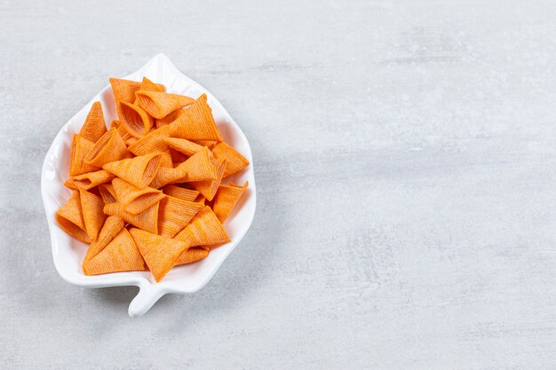 Tasty triangle chips on leaf shaped plate.