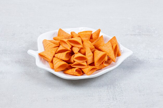 Tasty triangle chips on leaf shaped plate.