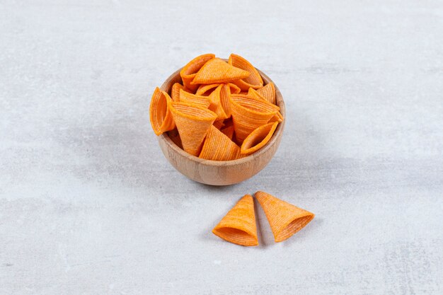 Tasty triangle chips in wooden bowl.