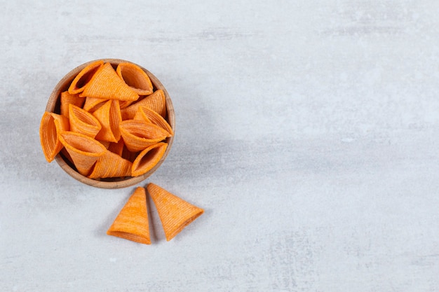 Tasty triangle chips in wooden bowl.