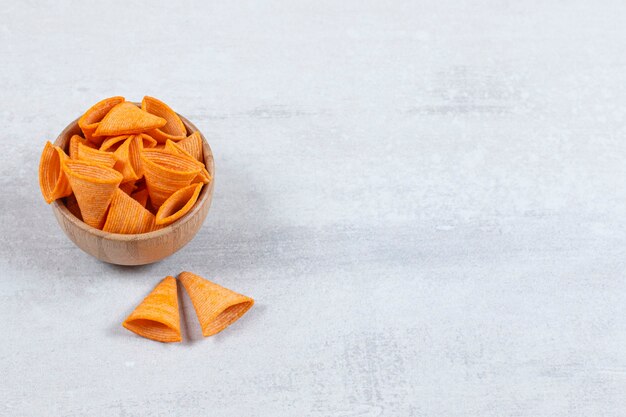 Tasty triangle chips in wooden bowl.