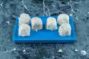 Free photo tasty turkish cotton candies on a wooden plate , on the blue background.