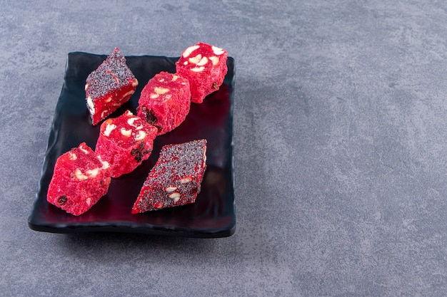 Tasty Turkish delights on a plate , on the marble background.