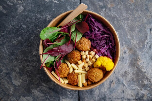 병아리콩 팔라펠과 잎을 곁들인 맛있는 채식주의자 샐러드는 종이 그릇에 담긴 건강한 삶 또는 폐기물 제로 개념