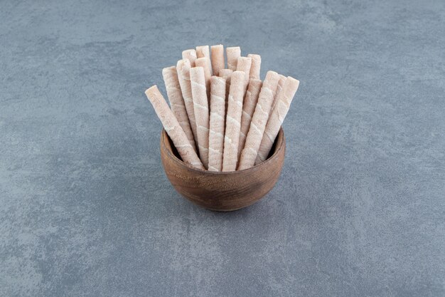 Tasty wafer rolls in wooden bowl.  