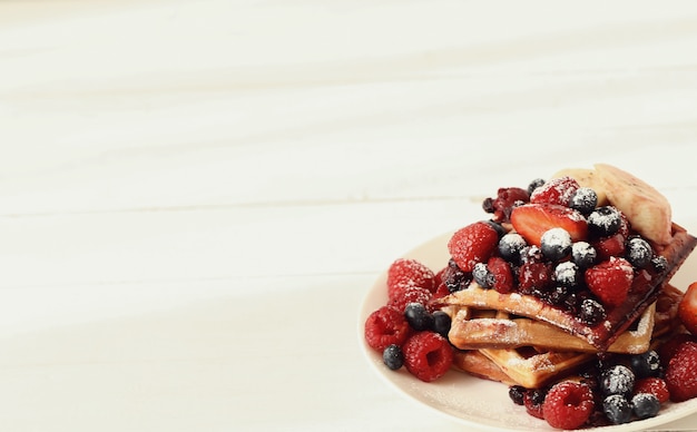 Tasty waffle with blueberries and strawberries