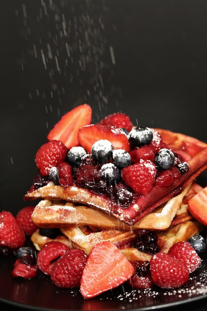 Tasty waffle with blueberries and strawberries