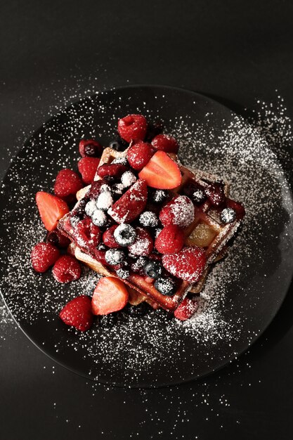 Tasty waffle with blueberries and strawberries