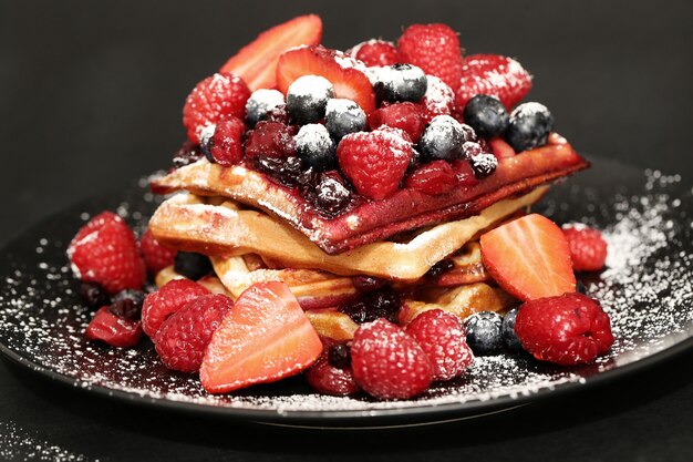 Tasty waffle with blueberries and strawberries