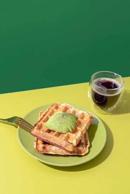 Tasty waffles with avocado high angle