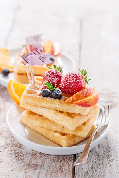 Tasty waffles with different pieces of fruit