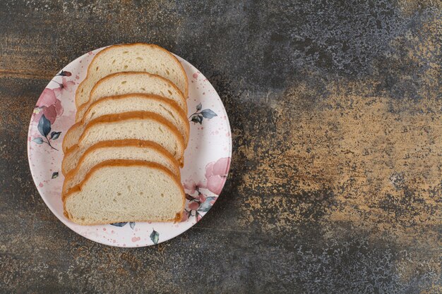 Вкусные кусочки белого хлеба на красочной тарелке.